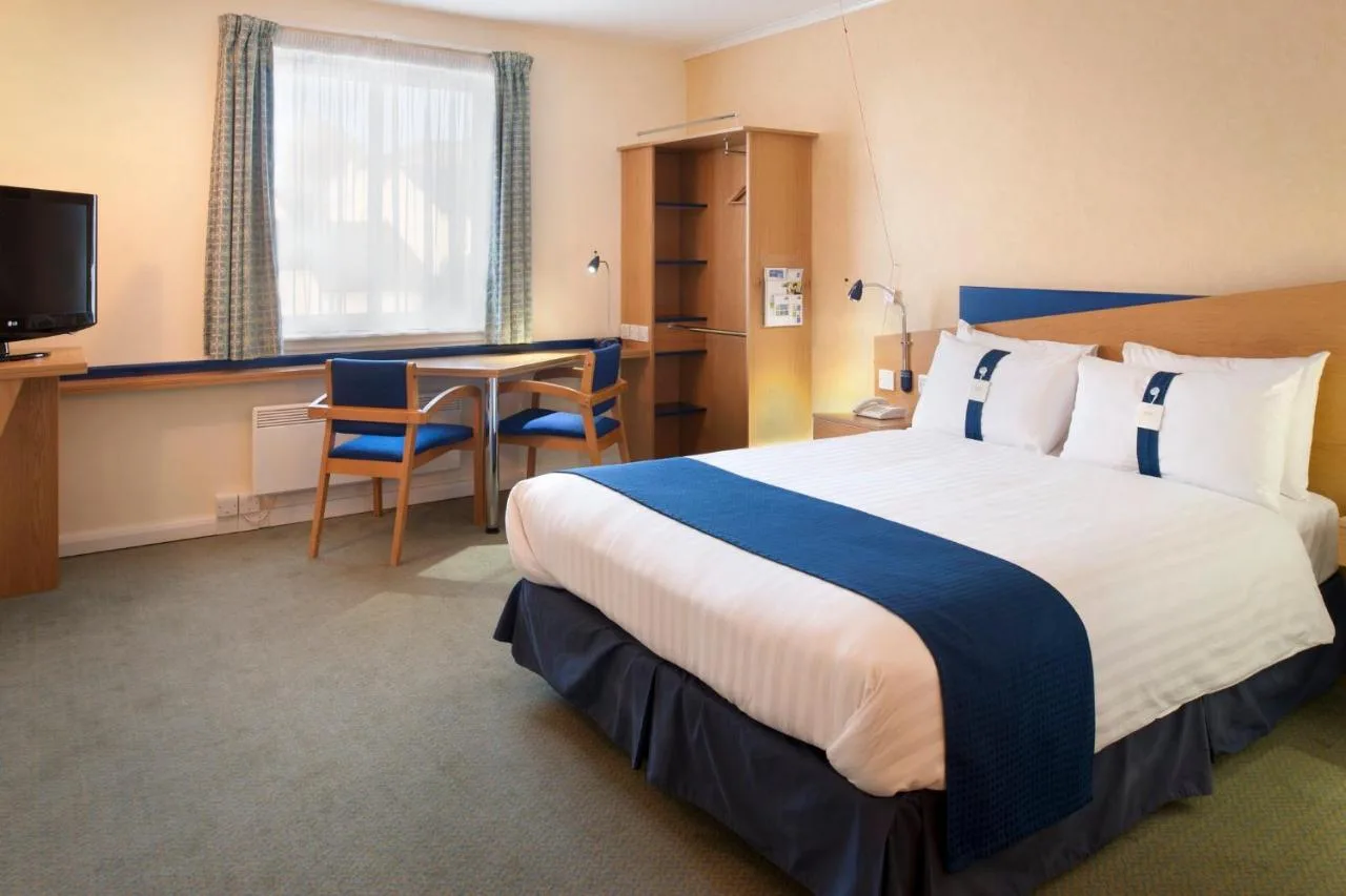 a hotel room with a large bed and a table at Holiday Inn Express Aberdeen City Centre by IHG in Aberdeen